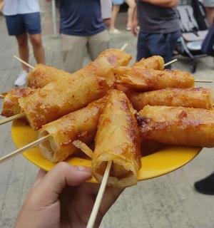 a person holding a plate of food with chop sticks