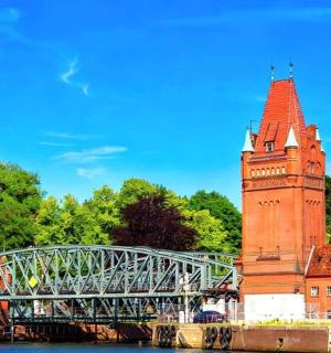 一座高大的钟楼,背景是一座桥