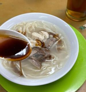 a bowl of soup on a green plate with a spoon