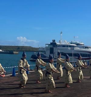 a group of people in uniform walking on a pier with a boat