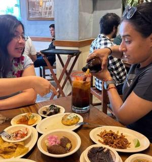 two women sitting at a table with plates of food