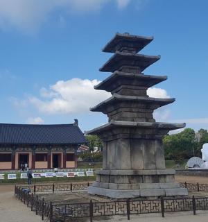 a statue in front of a building with a pagoda