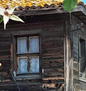 an old wooden house with two windows on it