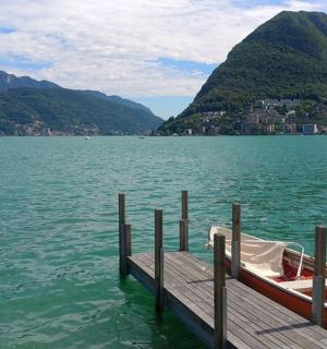 a dock with a boat on a lake with mountains