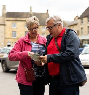 a man and a woman looking at a map on a street