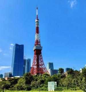 a red and white tower in front of a city