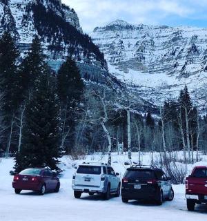 a group of cars parked in a parking lot in the snow