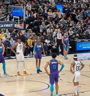 skupina basketbalových hráčů na hřišti s davem diváků