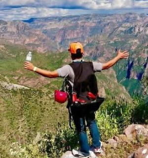 a man standing on top of a mountain with his arms outstretched