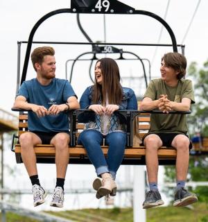 a group of three people sitting on a ski lift