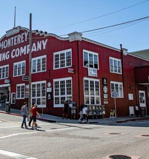 a red building on a street with people crossing the street