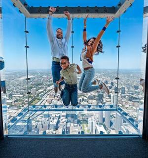 rodina skákající na skleněné podlaze mrakodrapu