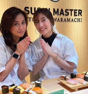 两个女人坐在一张桌子旁,桌上摆着寿司