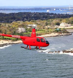 Červený vrtulník letí nad vodou