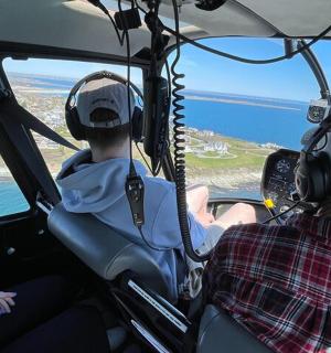 dva lidé sedící v kokpitu vrtulníku