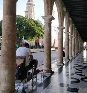 a man sitting in a chair under a building
