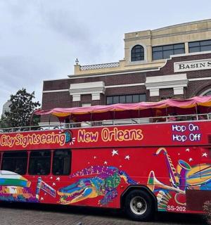 a red double decker bus parked in front of a building