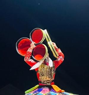 a woman is holding up a instrument in the air