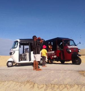 a group of people standing next to a car in the desert