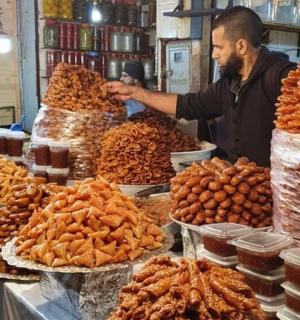 muž stojící na trhu s hromadou jídla