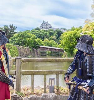 two people in armour standing next to a fence