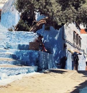 skupina lidí jdoucích po modré uličce