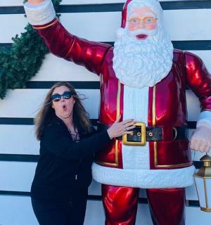 a woman standing next to a santa claus statue