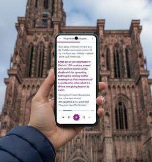 a person holding a cell phone in front of a building