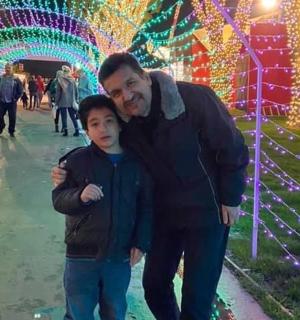 muž a chlapec kráčející před vánočními světly