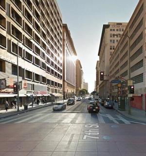 a city street with cars driving down a street with buildings