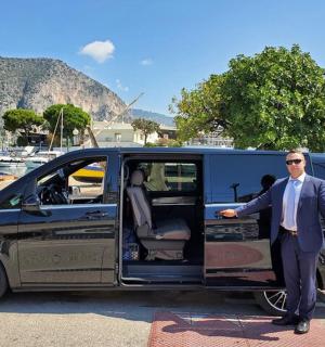 一名西装革履的男子站在一辆货车前