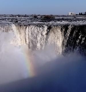 a rainbow sitting on top of a waterfall
