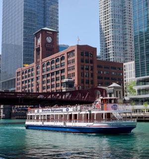 a boat on a river in a city with a bridge