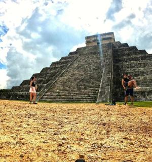 a group of people standing in front of a pyramid