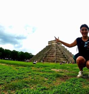 a man holding a camera in front of the pyramid