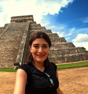 a woman standing in front of a pyramid