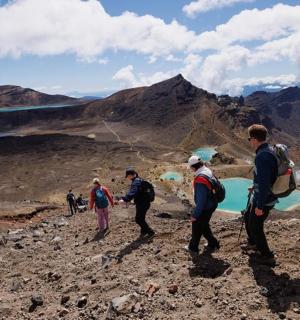 a group of people on a mountain flying a kite