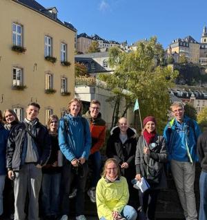 a group of people posing for a picture in front of buildings