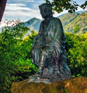 a statue of a woman sitting on a rock