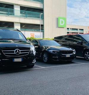 tři auta zaparkovaná na parkovišti před budovou