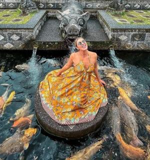 一个穿着裙子的女人在锦鲤池里