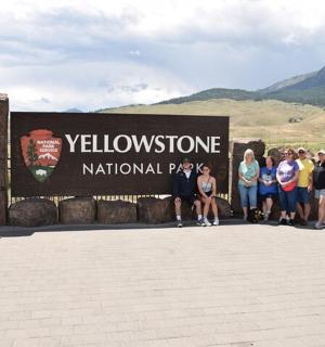 a group of people standing in front of a sign