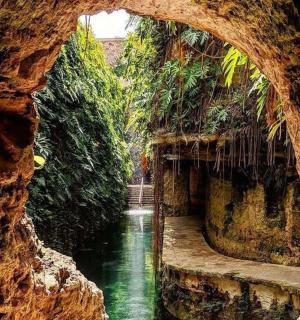 a view of a river through a stone cave