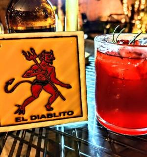 桌上的酒瓶旁边放着一杯饮料