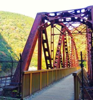 a red bridge over a river with a walkway