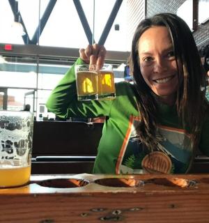 žena sedící u stolu se sklenicí piva