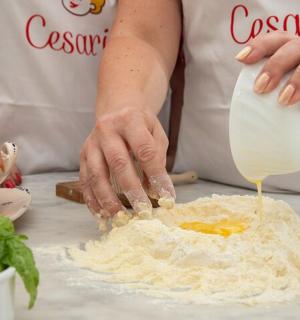 osoba, která nalévá sýr na hromadu jídla