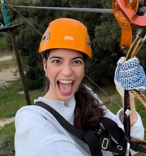 a woman in an orange helmet on a zip line