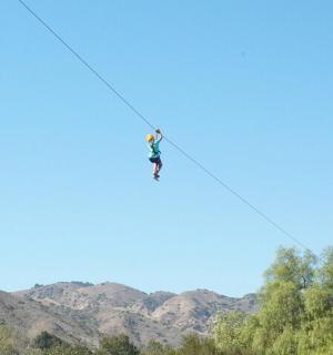 a person on a zip line in the sky
