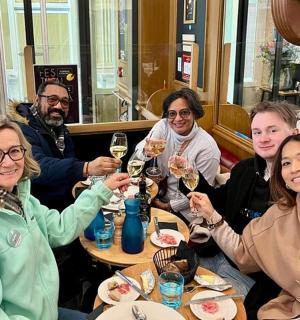 a group of people sitting at a table drinking wine